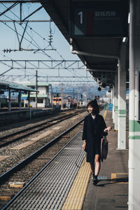 Full length of woman walking at railroad station