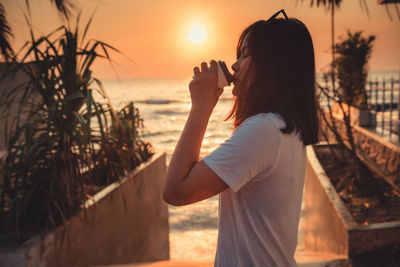 Woman drinking coffee at beach