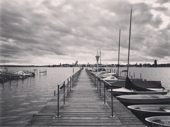 Wooden jetty in sea against sky