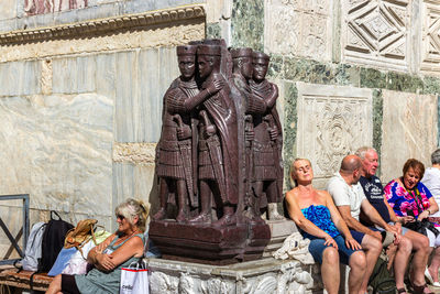 Statue of people in front of historical building