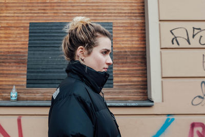 Portrait of girl standing against brick wall