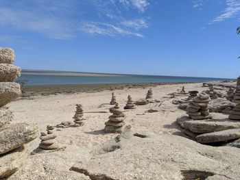 Scenic view of beach against sky with sculpture