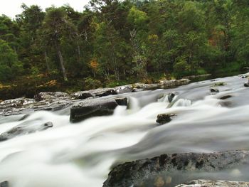 Scenic view of river flowing through rocks