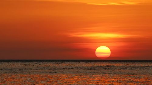 Scenic view of sea against orange sky