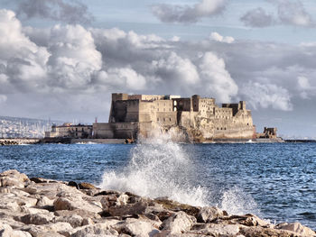 Scenic view of sea against sky with castle in naples