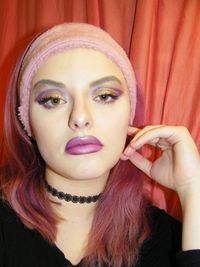 Close-up portrait of young woman wearing make-up at home