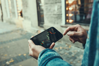 Person investing trading on stock cryptocurrency market using investing application on smartphone