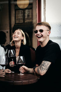 Portrait of a smiling young couple sitting on table at restaurant