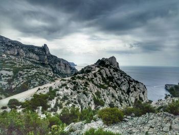 Scenic view of rocky mountains and sea against sky