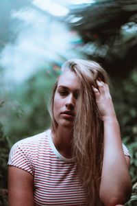 Close-up portrait of beautiful woman with hand in hair