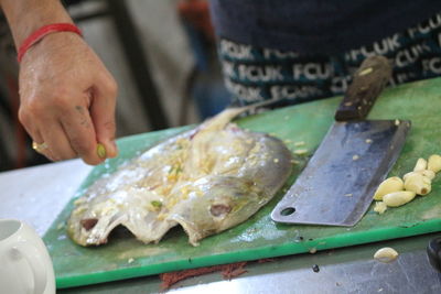 Close-up of man preparing fish on table