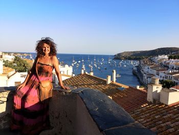 Woman standing by sea against clear sky