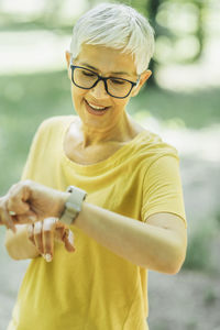 Intermittent walking workout. mature woman checking heart rate tracker during exercising break