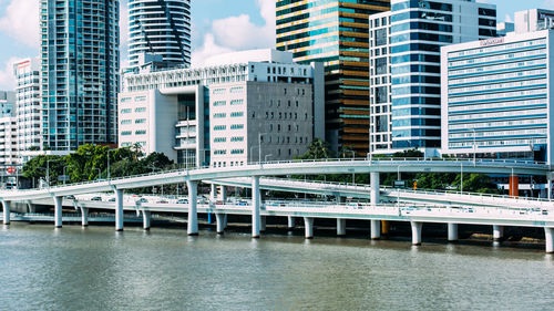 Bridge over river by buildings in city