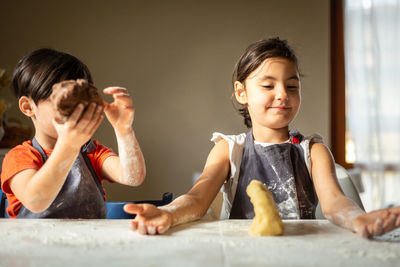 Two happy girls making a cake athome