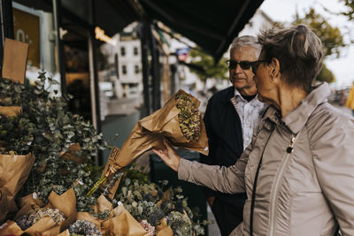 Senior couple choosing bouquet in flower shop