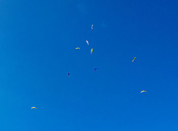 Low angle view of kite flying against clear blue sky