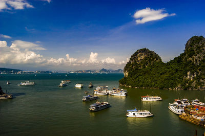 Sailboats moored in sea against sky