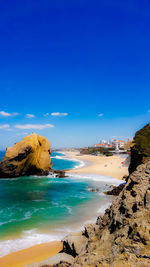 Scenic view of beach against blue sky