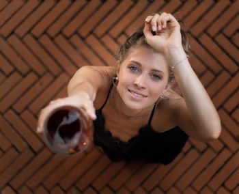 Directly above portrait of young woman holding wineglass