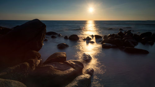 Sunset seascape with motion sea waves through natural stone arch at larn hin kaw, rayong, thailand.