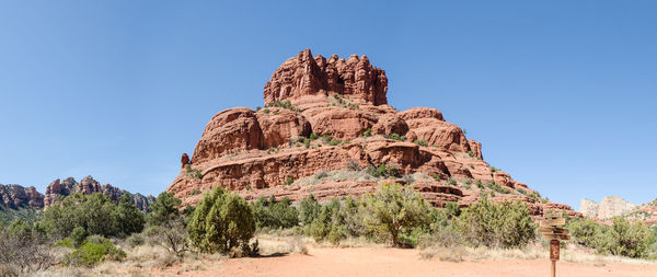 Rock formations on landscape against clear blue sky