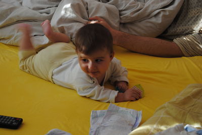 Cute baby boy lying on bed at home