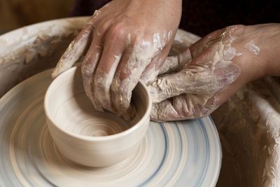 Cropped hand of woman making pottery