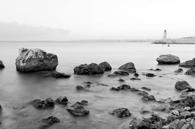 Rocks on sea shore against sky