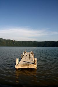 Wooden boat in lake against sky