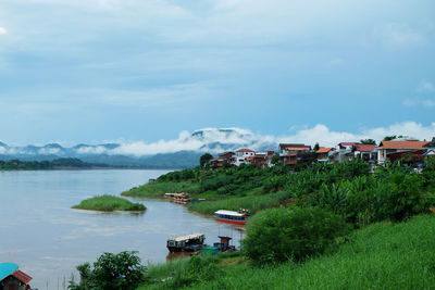 Houses by trees and buildings against sky