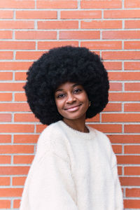 Portrait of young woman against wall