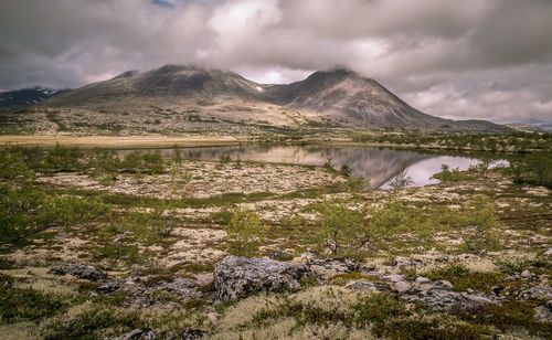 Scenic view of lake against cloudy sky