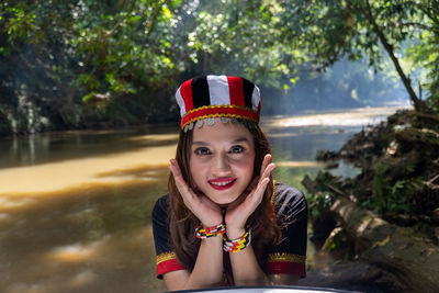 Naughty woman's facial action and using traditional borneo costumes at river