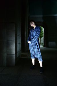 Woman looking away while standing in corridor