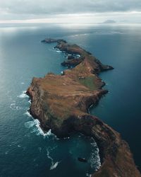 High angle view of rock formation in sea against sky