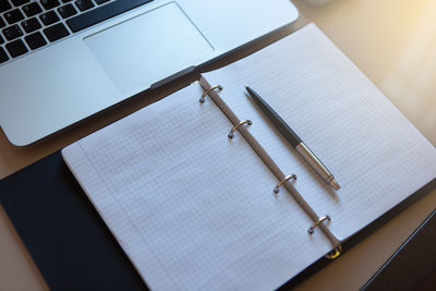 High angle view of laptop and book on table