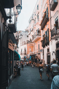 People walking on street amidst buildings in city