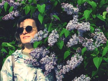 Low angle view of woman wearing sunglasses while standing by plants