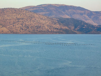 Scenic view of lake by mountains against sky