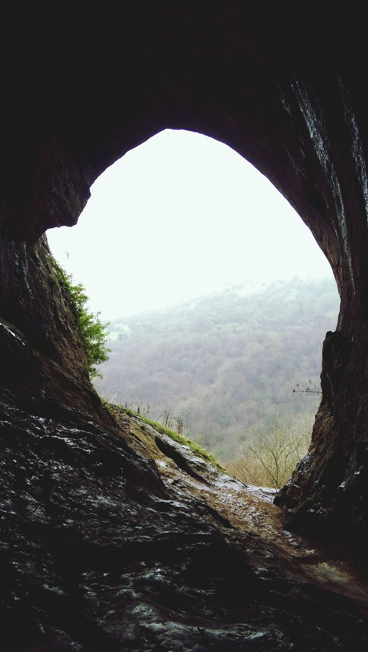 mountain, tranquility, tranquil scene, landscape, scenics, nature, beauty in nature, arch, non-urban scene, sky, tree, indoors, clear sky, rock formation, physical geography, mountain range, remote, day, idyllic, non urban scene