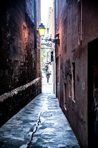 Rear view of man walking on alley