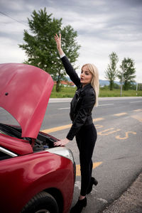 Full length of woman with umbrella on road