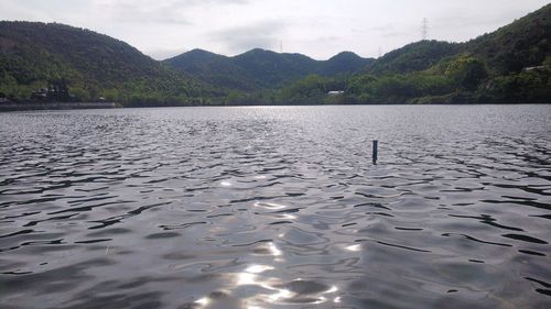 Scenic view of lake by mountains against sky