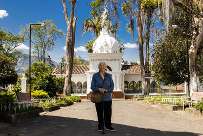 Rear view of woman standing against built structures