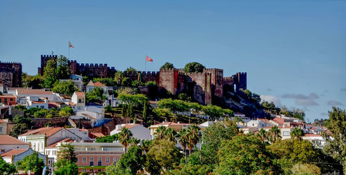 Buildings in city against clear blue sky