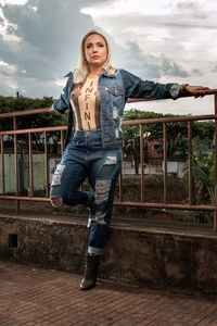 Portrait of a beautiful young woman against railing