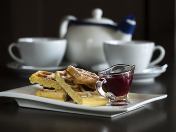 Close-up of belgian waffles with jam on table