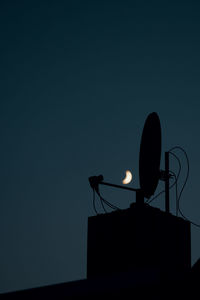 Low angle view of telephone pole against sky at dusk