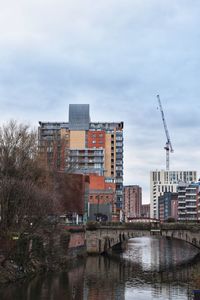River amidst buildings in city against sky